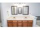 Double sink vanity with wood cabinets and framed mirrors with decorative lighting in the bathroom at 9078 N River Chase Ln, McCordsville, IN 46055