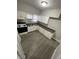 Compact kitchen featuring wood-look floors, white cabinetry, and an electric range at 1207 N Kealing Ave, Indianapolis, IN 46201