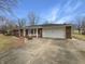 Charming brick home featuring an attached garage and a covered front porch with swing at 126 S Mustin Dr, Anderson, IN 46012
