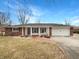 Charming brick ranch home featuring a two-car garage and a cozy front porch at 126 S Mustin Dr, Anderson, IN 46012