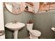 Charming powder room with a pedestal sink, decorative mirror, and stylish wall accents at 1307 Peregrine Ln, Greenwood, IN 46143