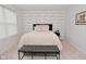 A cozy bedroom showcasing an accent wall and a tufted bench at the end of the bed at 1307 Peregrine Ln, Greenwood, IN 46143
