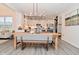 Open-concept dining area with a wooden table, bench seating, and pendant lighting connecting to the modern kitchen at 1307 Peregrine Ln, Greenwood, IN 46143