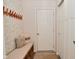 Charming entryway with patterned wallpaper, bench seating, and convenient coat rack for organized storage at 1307 Peregrine Ln, Greenwood, IN 46143