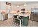 Modern kitchen with white cabinets, stainless steel appliances, and a stylish green kitchen island with seating at 1307 Peregrine Ln, Greenwood, IN 46143