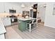 Bright, updated kitchen with white cabinetry, green island, and stainless appliances offer style and functionality at 1307 Peregrine Ln, Greenwood, IN 46143