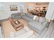 Open concept living room with large gray sectional sofa leading to kitchen and dining area at 1307 Peregrine Ln, Greenwood, IN 46143