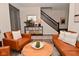 Inviting living room with leather chairs, wood floors, and views of the staircase and entryway at 1307 Peregrine Ln, Greenwood, IN 46143