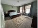 Spacious bedroom featuring a bed, carpet, and three windows with decorative curtains at 1347 Preserve Ct, Greenwood, IN 46143