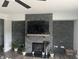 Close up on a modern fireplace with stone surround and mounted TV, accented with decorative plants and elegant details at 1347 Preserve Ct, Greenwood, IN 46143