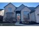 Charming brick home featuring a covered front entry, large windows, and professional landscaping at 13522 Spring Farms Dr, Carmel, IN 46032