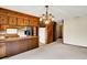 Open kitchen with wood cabinets, breakfast bar, and view into a separate living space at 14304 Adios Pass, Carmel, IN 46032