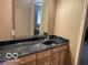 Bathroom vanity featuring a granite countertop and wood cabinets offering ample storage space and a practical design at 1437 E Pleasant Run Pkwy S Dr, Indianapolis, IN 46203