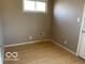 Simple bedroom with laminate flooring and a window providing natural light offering a blank canvas at 1437 E Pleasant Run Pkwy S Dr, Indianapolis, IN 46203