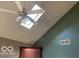 Angled ceiling with fan and skylight offering bright natural lighting, complemented by unique wall color combination at 1437 E Pleasant Run Pkwy S Dr, Indianapolis, IN 46203