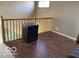 Upstairs room with wood flooring, railing overlooking the stairs, and a vintage box adding charm at 1437 E Pleasant Run Pkwy S Dr, Indianapolis, IN 46203