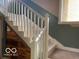 Classic staircase with detailed woodwork and custom built-in storage beneath, adding functionality and style at 1437 E Pleasant Run Pkwy S Dr, Indianapolis, IN 46203