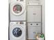 Modern laundry room with stacked washer and dryer, gray cabinets and wicker basket at 14904 Tiago Ln, Fishers, IN 46040