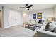 A bright living room boasts neutral walls, modern ceiling fan, and contemporary furnishings at 14904 Tiago Ln, Fishers, IN 46040