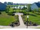 Aerial view of a charming pergola with seating, set amidst lush landscaping and overlooking a serene pond at 14904 Tiago Ln, Fishers, IN 46040