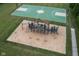 Aerial view of the community playground with unique climbing structures and soft landing, surrounded by green spaces at 14904 Tiago Ln, Fishers, IN 46040