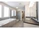Well-lit bathroom featuring a soaking tub, glass-enclosed shower, vanity sink, and tile flooring at 15694 Provincial Ln, Fishers, IN 46040
