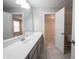 Bathroom vanity with gray cabinets, white countertop, mirror, with view into an adjacent bedroom at 15694 Provincial Ln, Fishers, IN 46040
