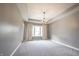 Spacious carpeted bedroom with tray ceiling, modern light fixture, and light-filled window with curtains at 15694 Provincial Ln, Fishers, IN 46040