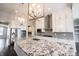 Elegant kitchen featuring granite countertops, stylish pendant lighting, stainless steel appliances, and white cabinets at 15694 Provincial Ln, Fishers, IN 46040