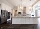 Spacious kitchen featuring white cabinets, a large island with granite countertops, and stainless steel appliances at 15694 Provincial Ln, Fishers, IN 46040