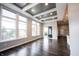 Well-lit, open-concept room with hardwood floors, a coffered ceiling, and large windows at 15694 Provincial Ln, Fishers, IN 46040