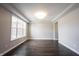 Bright living room with tray ceilings and wood floors illuminated by a large window at 15694 Provincial Ln, Fishers, IN 46040