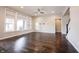 Bright living room with hardwood floors, large windows, and a ceiling fan for a comfortable atmosphere at 15694 Provincial Ln, Fishers, IN 46040