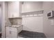 A mudroom is presented with a built in bench, wall hooks, and cabinets with a granite countertop at 15694 Provincial Ln, Fishers, IN 46040