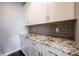 This pantry features white cabinets, granite countertops, and gray subway tile backsplash at 15694 Provincial Ln, Fishers, IN 46040