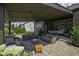 Inviting covered patio with comfortable seating, stone flooring, and brick accents at 15694 Provincial Ln, Fishers, IN 46040