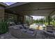 Relaxing covered patio featuring a pool, fire pit, comfortable seating, and manicured landscaping at 15694 Provincial Ln, Fishers, IN 46040