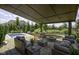 Serene covered patio showcasing a fire pit, pool, comfortable seating, and lush landscaping at 15694 Provincial Ln, Fishers, IN 46040