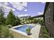 Inviting pool with stone surround, pergola, and lush landscaping in this beautiful backyard at 15694 Provincial Ln, Fishers, IN 46040