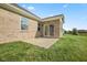 Brick home with a backyard patio and lush green lawn at 1692 S Centennial Ave, New Palestine, IN 46163