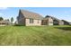 A lush green backyard featuring a brick house with a patio, perfect for outdoor living at 1692 S Centennial Ave, New Palestine, IN 46163