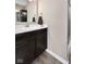 Bathroom featuring dark vanity, countertop, mirror, and glass shower at 1692 S Centennial Ave, New Palestine, IN 46163