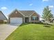 Charming brick home featuring an attached two car garage and manicured lawn at 1692 S Centennial Ave, New Palestine, IN 46163