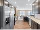 Bright, modern kitchen with stainless steel fridge and open floor plan to dining area at 1692 S Centennial Ave, New Palestine, IN 46163