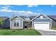 Charming single-story home boasts blue siding, stone accents, a two-car garage, and a well-manicured lawn at 19714 Highclere Ln, Sheridan, IN 46069