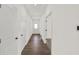 Bright hallway featuring wood flooring, white walls, and multiple doors leading to various rooms at 19714 Highclere Ln, Sheridan, IN 46069