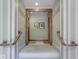 Neutral hallway featuring unique striped wallpaper and wooden banister leading to carpeted stairs at 198 E Madison St, Franklin, IN 46131