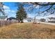 A wide shot of the backyard, showing grass and fallen leaves on the ground, as well as the alley access garage at 2002 Fisher Ave, Indianapolis, IN 46224