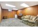 Spacious basement with wood paneling, neutral carpet, and a tan sofa with space for a workspace at 2002 Fisher Ave, Indianapolis, IN 46224