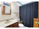 Bathroom featuring a wood frame mirror, vanity with sink, toilet, and a shower with a dark curtain at 2002 Fisher Ave, Indianapolis, IN 46224